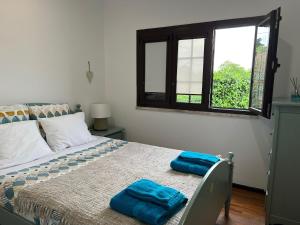 a bedroom with a bed with two blue towels on it at Rustic Villa with Private Pool near Ericeira in Mafra +50 photos