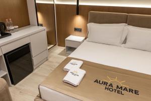 a hotel room with a bed with two towels on it at Aura Mare Hotel in Ksamil
