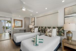 a hotel room with two beds and a couch at The Hale Pau Hana in Kihei +71 photos
