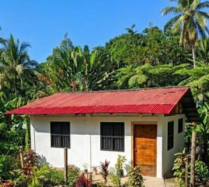 a small white house with a red roof at Cabaña Villa Samantha in Buenaventura