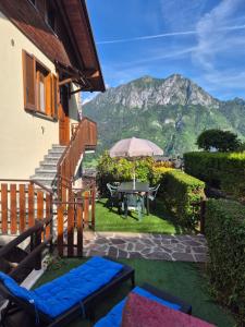 a patio with a table and an umbrella and a mountain at Dream View Mountains House in Valgoglio