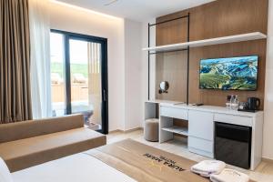 a living room with a tv on a wall at Aura Mare Hotel in Ksamil