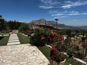 a garden with flowers and a fence with mountains in the background at Cortijo Algüit in Vélez Blanco