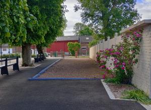 a pathway with a fence and flowers next to a building at La maison d'Arthur et Armelène in Rely