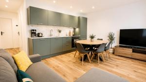 a kitchen and dining room with a table and a television at Immeuble privatif 3 logements et 1 logement non loin de l'immeuble in Le Portel