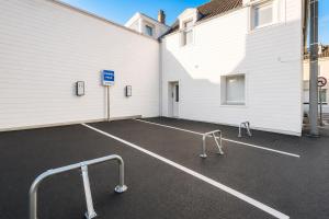 an empty parking lot next to a white building at Immeuble privatif 3 logements et 1 logement non loin de l'immeuble in Le Portel
