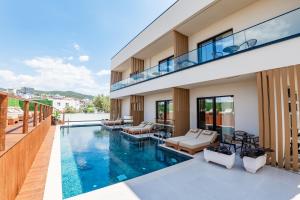 a house with a swimming pool and a balcony at Aura Mare Hotel in Ksamil