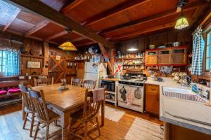 a kitchen with a wooden table and a dining room at Cozy Cabin w Pavilion Deck Fireplace & FirePit in Terra Alta