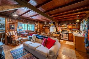 a living room with a couch and a kitchen at Cozy Cabin w Pavilion Deck Fireplace & FirePit in Terra Alta