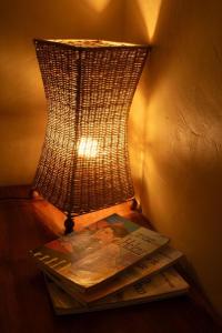 a lamp sitting on a table with a book at Quinta dos Laranjais Chalés in Viçosa do Ceará +211 photos