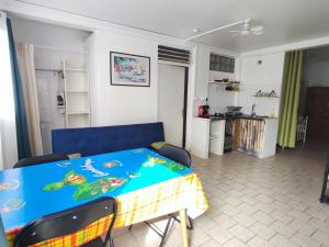 a dining room and living room with a blue table at Marilou in Basse-Terre