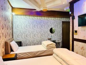 a room with two beds and a wall at Sea Shell Service Apartment in Bāiljuri