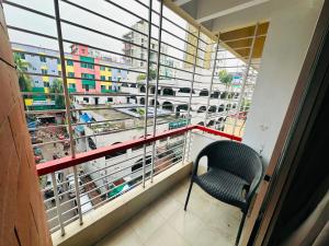 a balcony with a chair and a view of a city at Sea Shell Service Apartment in Bāiljuri