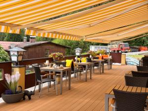 a patio with tables and chairs on a deck at Residenz Dunza Hotel Garni in Bürserberg