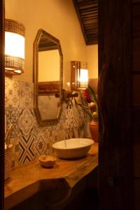 a bathroom with a sink and a mirror on a counter at Quinta dos Laranjais Chalés in Viçosa do Ceará
