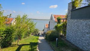 a path between two buildings with a view of the water at Apartmán Pálava 1 s terasou a výhledem na jezero in Pavlov