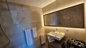 a bathroom with a sink and a mirror at Feel Home Apartment in Dornbirn +66 photos