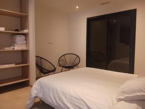 a bedroom with a bed and two chairs in it at Villa Ezilia in Alata