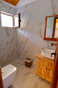 a bathroom with a white toilet and a sink at Bujtinat e Delvinës in Delvinë