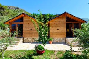 a small wooden house with a porch in a yard at Bujtinat e Delvinës in Delvinë