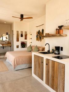a bedroom with a bed and a kitchen with a sink at Maison de Reve - Boutique Guest House in Brisas de Zicatela