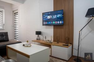 a living room with a tv on a wall at М Apartments Shtip in Štip