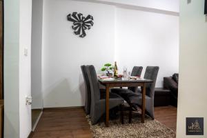 a dining room table with chairs and a clock on the wall at М Apartments Shtip in Štip