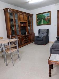 a living room with a couch and a table and chairs at O Recuncho da Xunqueira in Viveiro +1 photo