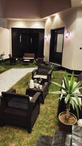 a living room with black furniture and a potted plant at شاليه لوسيندا 2 in Baljurashi
