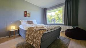 a bedroom with a bed and a window at Modern, spacious villa with Sauna in Ruds-Vedby