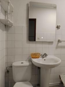 a white bathroom with a toilet and a sink at O Recuncho da Xunqueira in Viveiro
