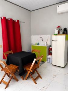 a kitchen with a table and two chairs and a refrigerator at Studio Brasiléia in Brasiléia