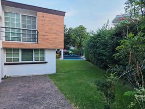 a backyard of a house with a grass yard at Cocoyoc Residential Estate in Texcalpan