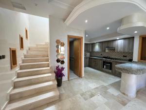 a kitchen with stairs and a kitchen with a counter at Villa Marina à Savannah Beach sidi rahal in Sidi Rahal