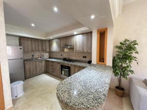 a kitchen with a granite counter top in a room at Villa Marina à Savannah Beach sidi rahal in Sidi Rahal