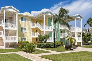 a large apartment building with white balconies and palm trees at Westgate Bimini Bay in Bailey Town
