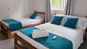 a room with two beds with blue and white sheets at Cabaña Los Cristales Coveñas by Amauna in Coveñas +37 photos