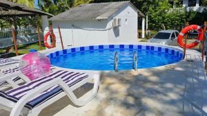 a swimming pool with a chair and a swing at Cabaña Los Cristales Coveñas by Amauna in Coveñas