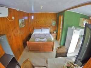 um quarto com uma cama numa parede de madeira em Chalés Rincão Comprido em Canela