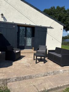 a patio with two couches and a table and chairs at Grange in Saint-Paul-Mont-Penit +3 photos