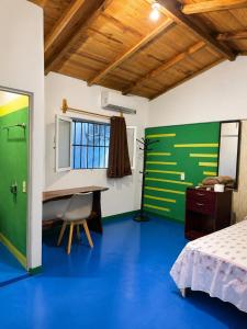 a room with a bed and a desk and a table at Casa Mahue in Puerto Escondido +12 photos