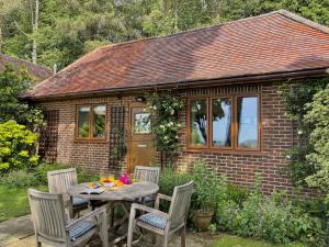 a table and chairs in front of a small house at Wyndthorpe Cottage in Milton Abbas +24 photos