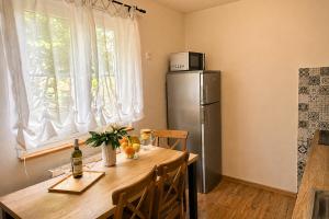 a kitchen with a wooden table and a refrigerator at Apartmány Lipno 46 in Lipno nad Vltavou
