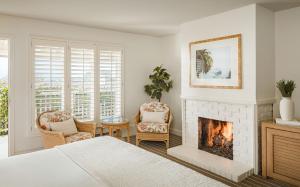 a bedroom with a fireplace and two chairs at Hotel Carmel in Carmel