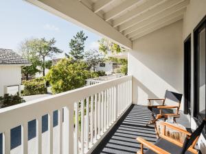 a balcony with two rocking chairs on a house at Hotel Carmel in Carmel