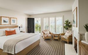 a hotel room with a bed and a table and chairs at Hotel Carmel in Carmel