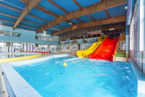 a swimming pool with a slide in the water at OWR Piramida 2 in Darlowko