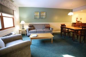 a living room with a couch and a table at Deer Park Condo 165D Vacation Rental near Loon Mountain in Woodstock
