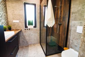 a bathroom with a glass shower and a sink at Rumiane Chatki - Domki z Jacuzzi i Basenem in Rybno +22 photos