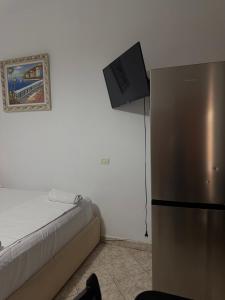 a room with a refrigerator and a tv on the wall at Vila Vladmir Sela in Ksamil